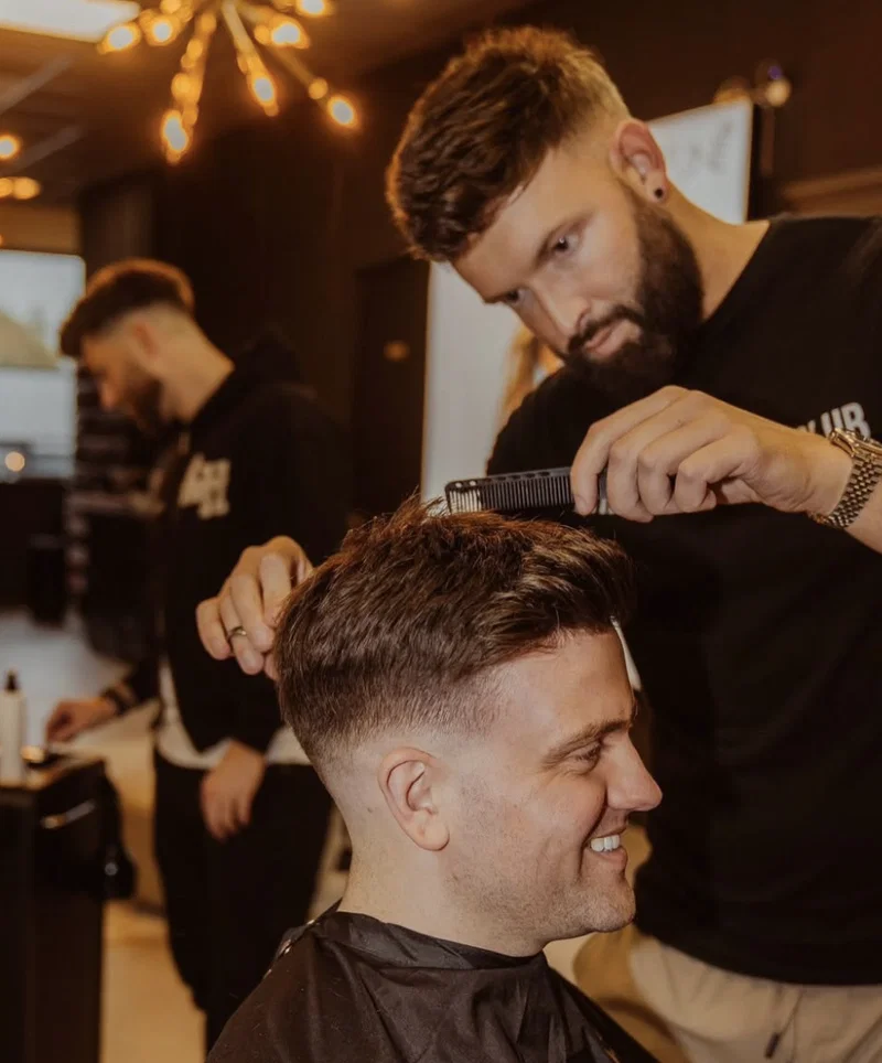 Tom Walker, founder of Hair Repair Club, fitting and styling a client's hair system
